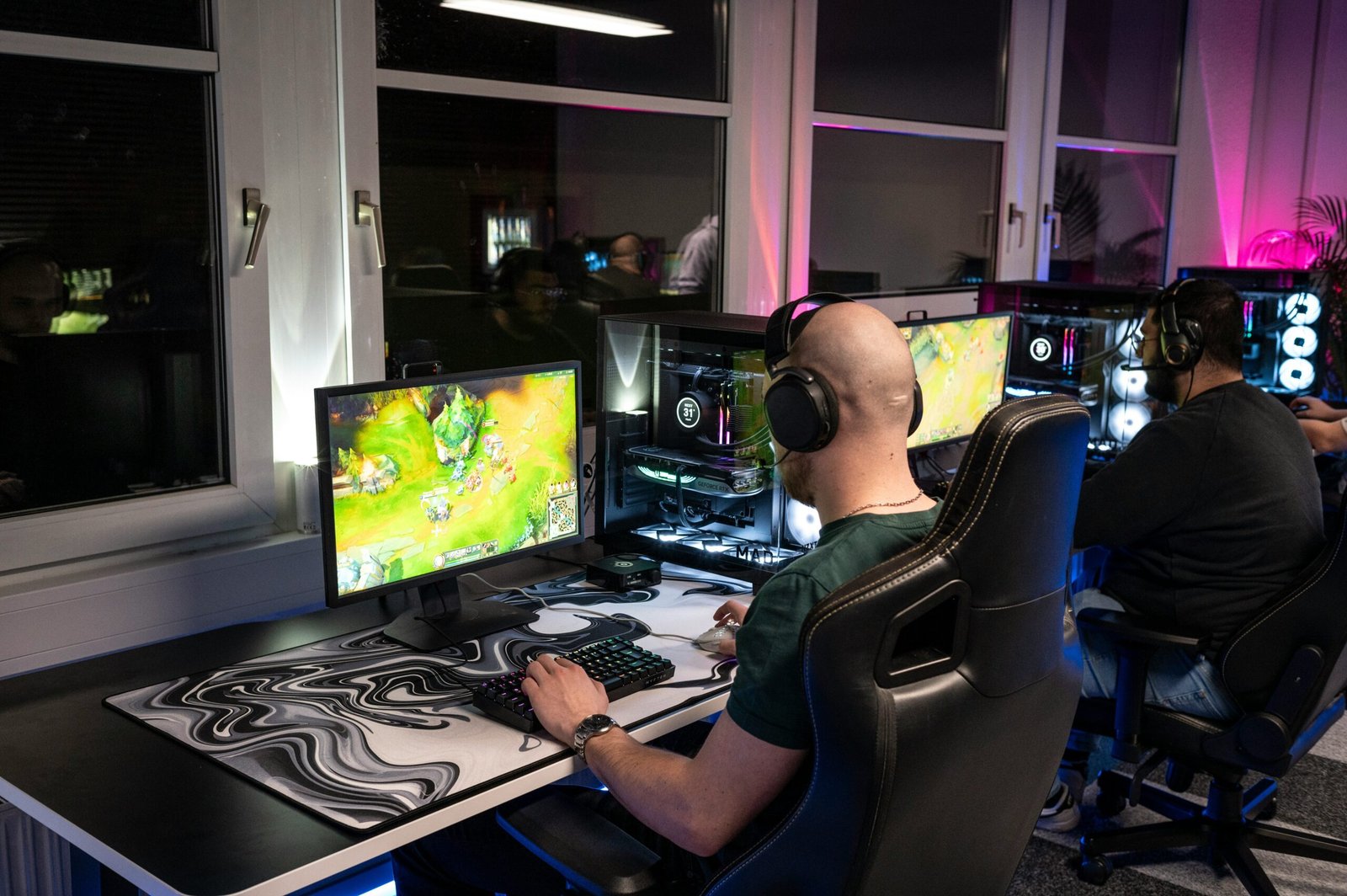 A packed arena filled with cheering Overwatch League fans holding signs.